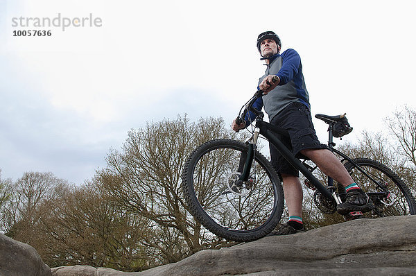 Älterer Mountainbiker mit Blick auf die Felsformation