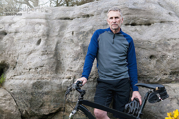 Porträt eines männlichen Mountainbikers auf einer Felsformation