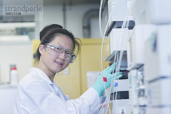 Porträt einer jungen Wissenschaftlerin mit wissenschaftlichen Geräten im Labor