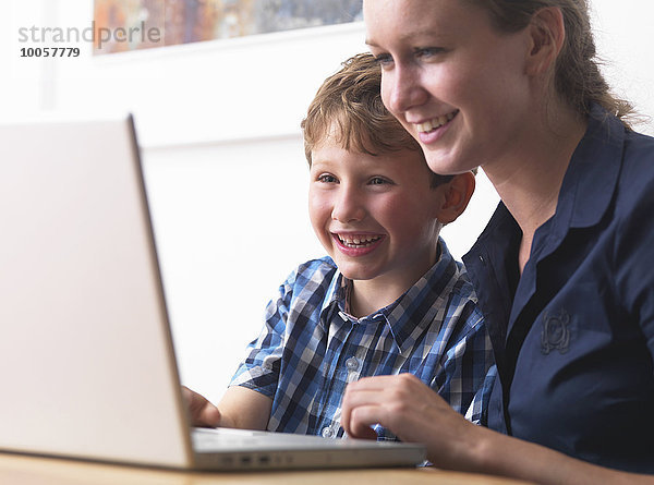 Junge Frau und Sohn mit Laptop zu Hause