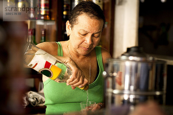 Frau serviert Schnaps in der Bar