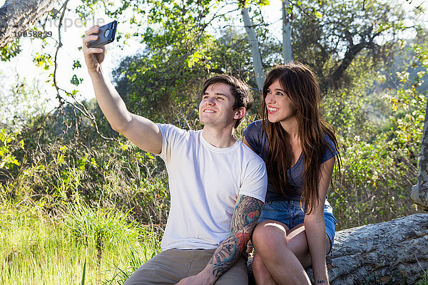 Junges Paar mit Smartphone Selfie im Park
