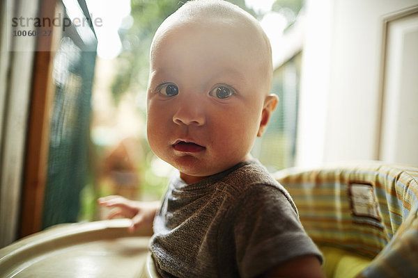 Porträt eines kleinen Jungen mit Blick auf die Kamera im Hochstuhl