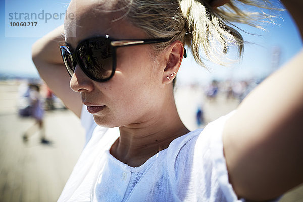Porträt einer Frau mit Sonnenbrille  die Haare hochsteckt