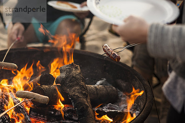 Gruppe von Freunden beim Grillen am Strand