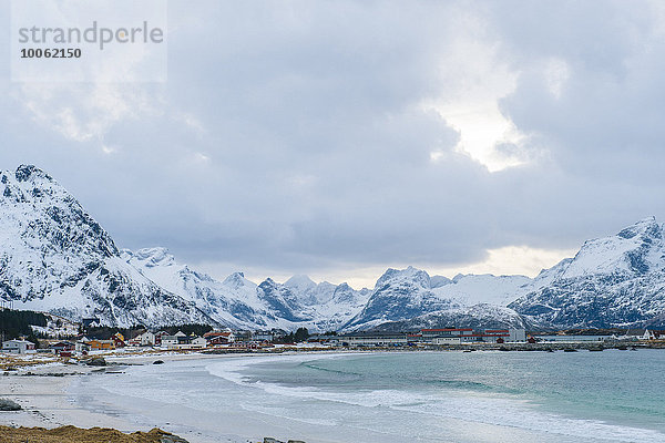 Fernsicht auf das Dorf am Wasser und die schneebedeckten Berge  Reine  Lofoten  Norwegen