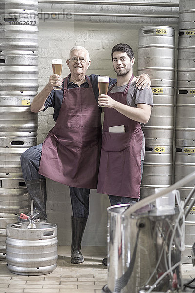 Zwei Biertrinker in der Brauerei  neben den Fässern