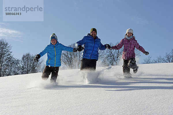 Vater und zwei Kinder laufen im tiefen Schnee  Bad Heilbrunn  Oberbayern  Bayern  Deutschland  Europa