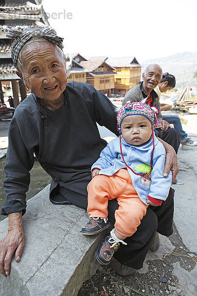 Alte Dong Frau mit Enkel mit traditionellem Kopfschmuck  Tang'an  Provinz Guizhou  China  Asien