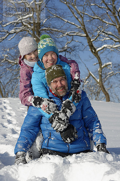Vater und seine Kindern toben im Schnee  Bad Heilbrunn  Oberbayern  Bayern  Deutschland  Europa