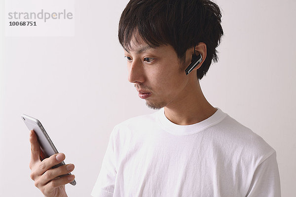 benutzen Mann Internet jung Kopfhörer japanisch Smartphone