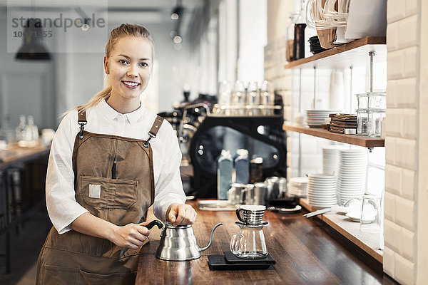 Porträt einer glücklichen Barista an der Theke im Coffee Shop