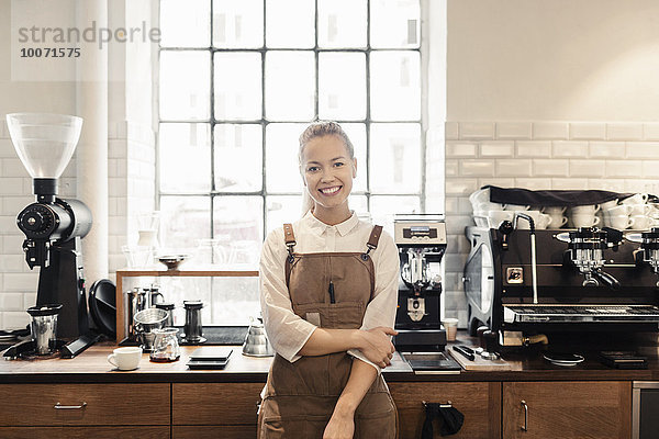 Porträt einer glücklichen Barista am Tresen im Coffee Shop