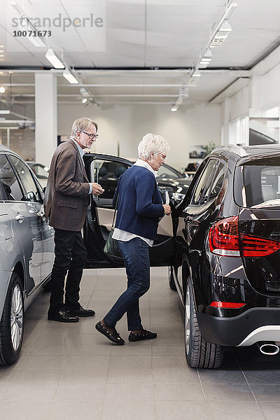 Seniorenpaar untersucht Auto im Geschäft