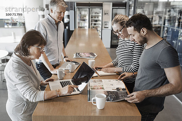Multiethnische Geschäftsleute  die am Schalter im Bürocafé arbeiten