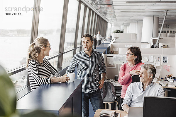 Geschäftsleute diskutieren in der Kabine im Büro