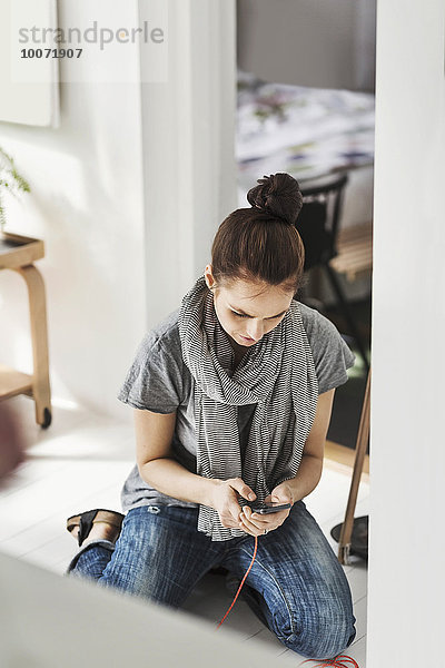 Frau mit Handy im Home-Office