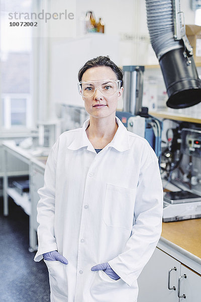 Porträt einer selbstbewussten Wissenschaftlerin mit den Händen in der Tasche im Labor