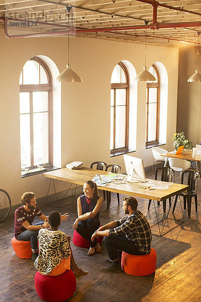 Kreative Geschäftsleute reden im Kreis im Büro