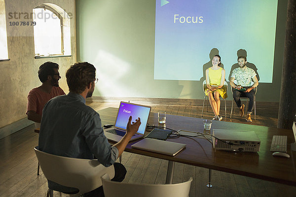 Geschäftsleute bei der Vorbereitung einer audiovisuellen Präsentation auf Focus