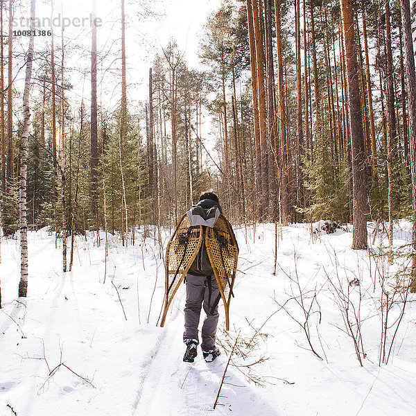 Mann tragen Schnee Wald Schneeschuh