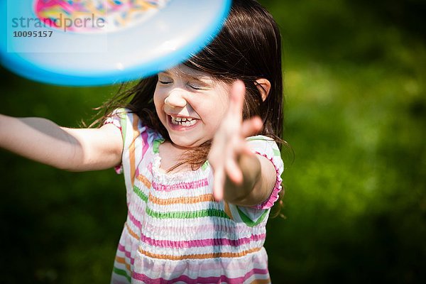 Junges Mädchen wirft Frisbee in den Garten