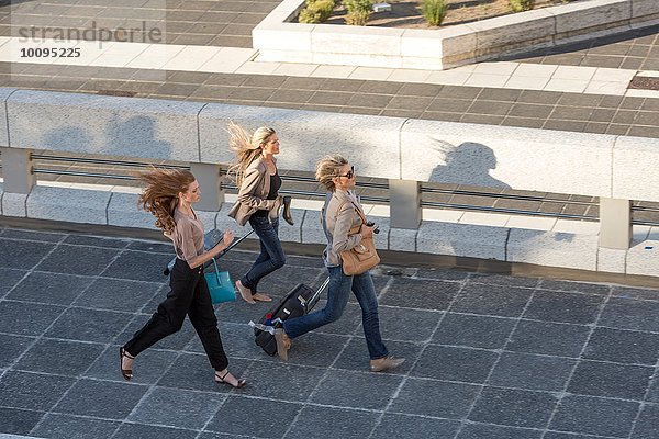 Drei erwachsene Frauen  die über einen erhöhten Steg laufen