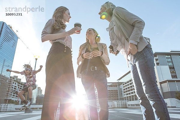 Niedriger Blickwinkel auf erwachsene Frauen im Stehen und Sprechen