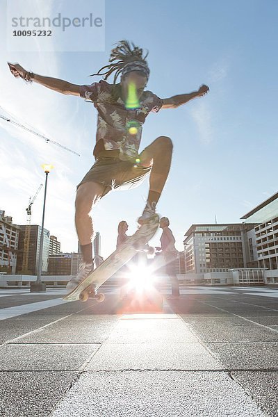 Junger Mann im Stadtgebiet beim Skateboarden