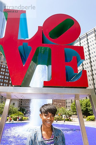 Porträt eines jungen Mannes vor rotem Liebeszeichen  Philadelphia  Pennsylvania  USA