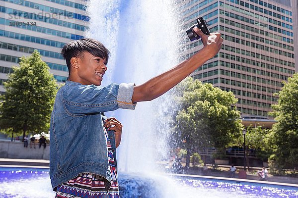 Junger Mann beim Selbstporträt neben dem Wasserbrunnen  Philadelphia  Pennsylvania  USA