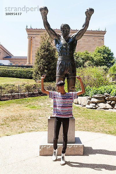 Junger Mann imitiert Pose vor der Parkstatue  Philadelphia  Pennsylvania  USA