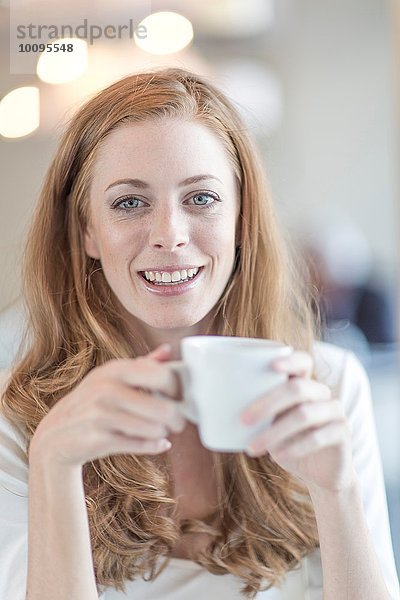 Porträt einer jungen Geschäftsfrau beim Kaffeetrinken
