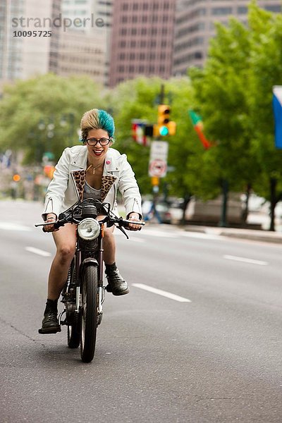Porträt einer jungen Frau mit bunten Haaren  Motorradfahren