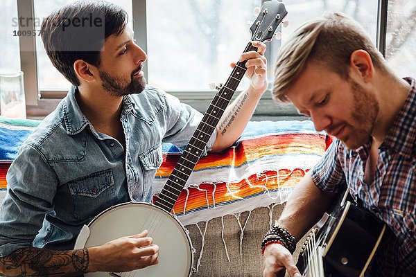 Männliches Paar zu Hause  Gitarre und Banjo spielen