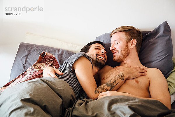 Männliches Paar im Bett  umarmend  von Angesicht zu Angesicht