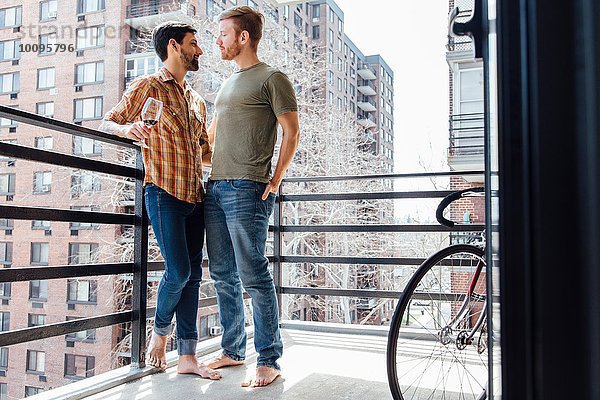 Männliches Paar auf dem Balkon stehend  von Angesicht zu Angesicht