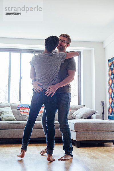 Männliches Paar zu Hause  gemeinsam tanzen  von Angesicht zu Angesicht