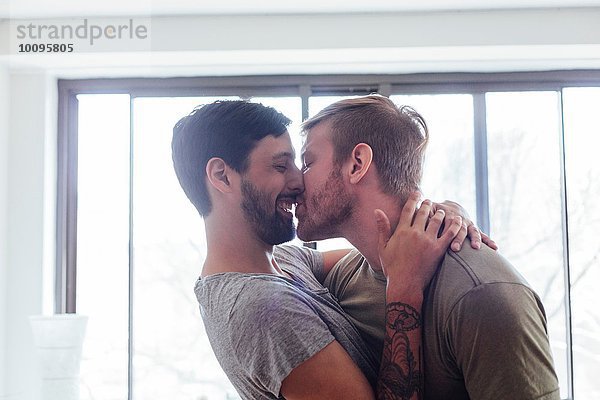 Männliches Paar zu Hause  herumalbern  küssen und lachen
