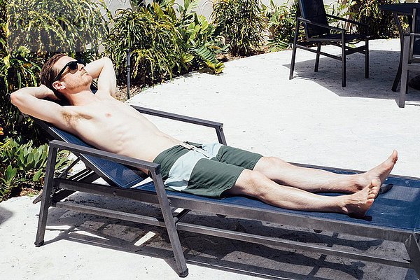 Mittlerer Erwachsener Mann beim Sonnenbaden auf der Liege  Miami Beach  Florida  USA