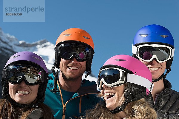 Vier Freunde mit Skihelmen und Schutzbrille  lachend