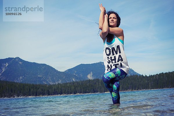 Mittlere erwachsene Frau  stehend im See  in Yogastellung  tiefer Blickwinkel