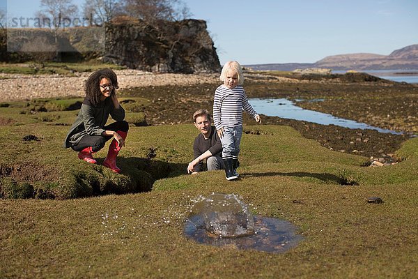 Junge wirft Stein in die Pfütze  Isle of Skye  Hebriden  Schottland
