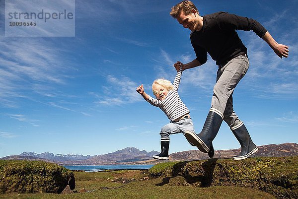 Vater und Sohn beim Händchenhalten  Isle of Skye  Hebriden  Schottland