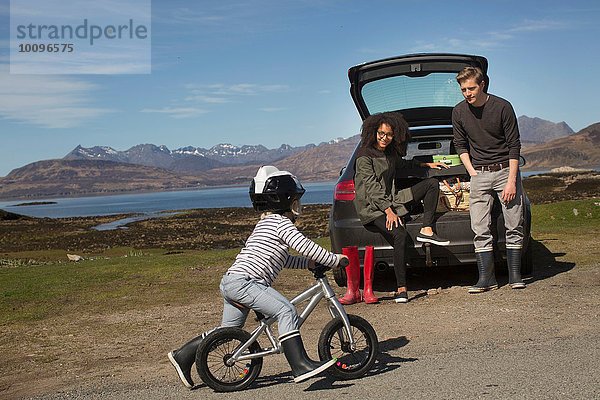 Eltern beobachten Sohn Fahrrad fahren  Loch Eishort  Isle of Skye  Hebrides  Schottland