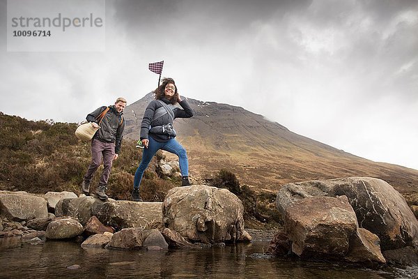 Paar überquert Fluss  Fairy Pools  bei Glenbrittle  Isle of Skye  Hebriden  Schottland