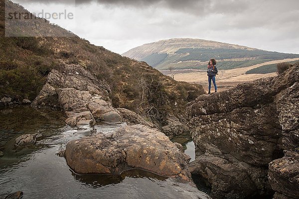 Frau auf Felsen stehend  Fairy Pools  Isle of Skye  Hebrides  Schottland