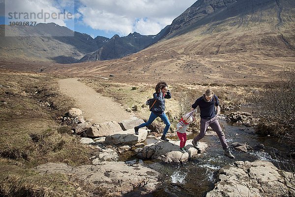 Family crossing stream  Fairy Pools  Isle of Skye  Hebriden  Schottland