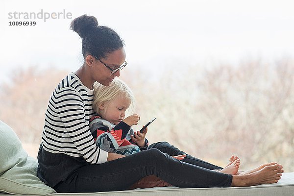 Mutter und Sohn sitzen zusammen mit Tablette