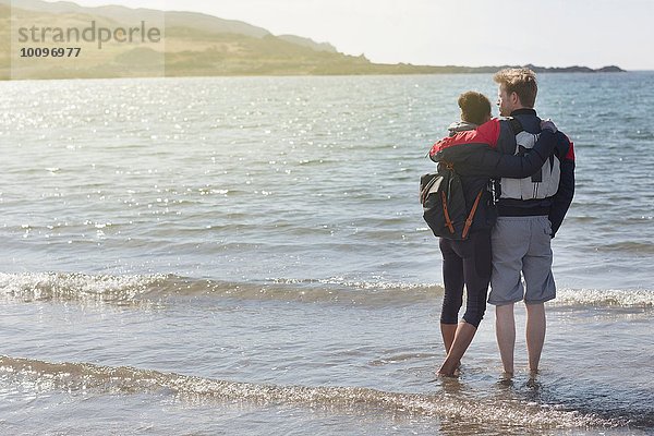 Mittleres erwachsenes Paar mit Armen umeinander am Strand  Loch Eishort  Isle of Skye  Hebrides  Schottland